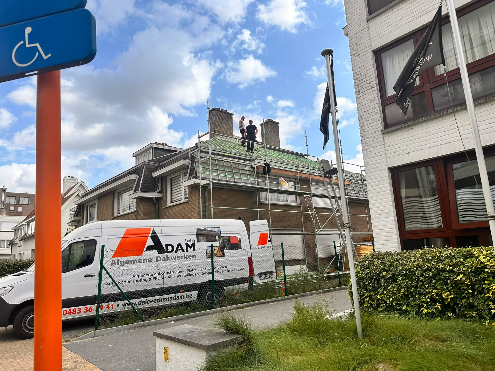 Dakwerkers aan dakterenovatie met steiger