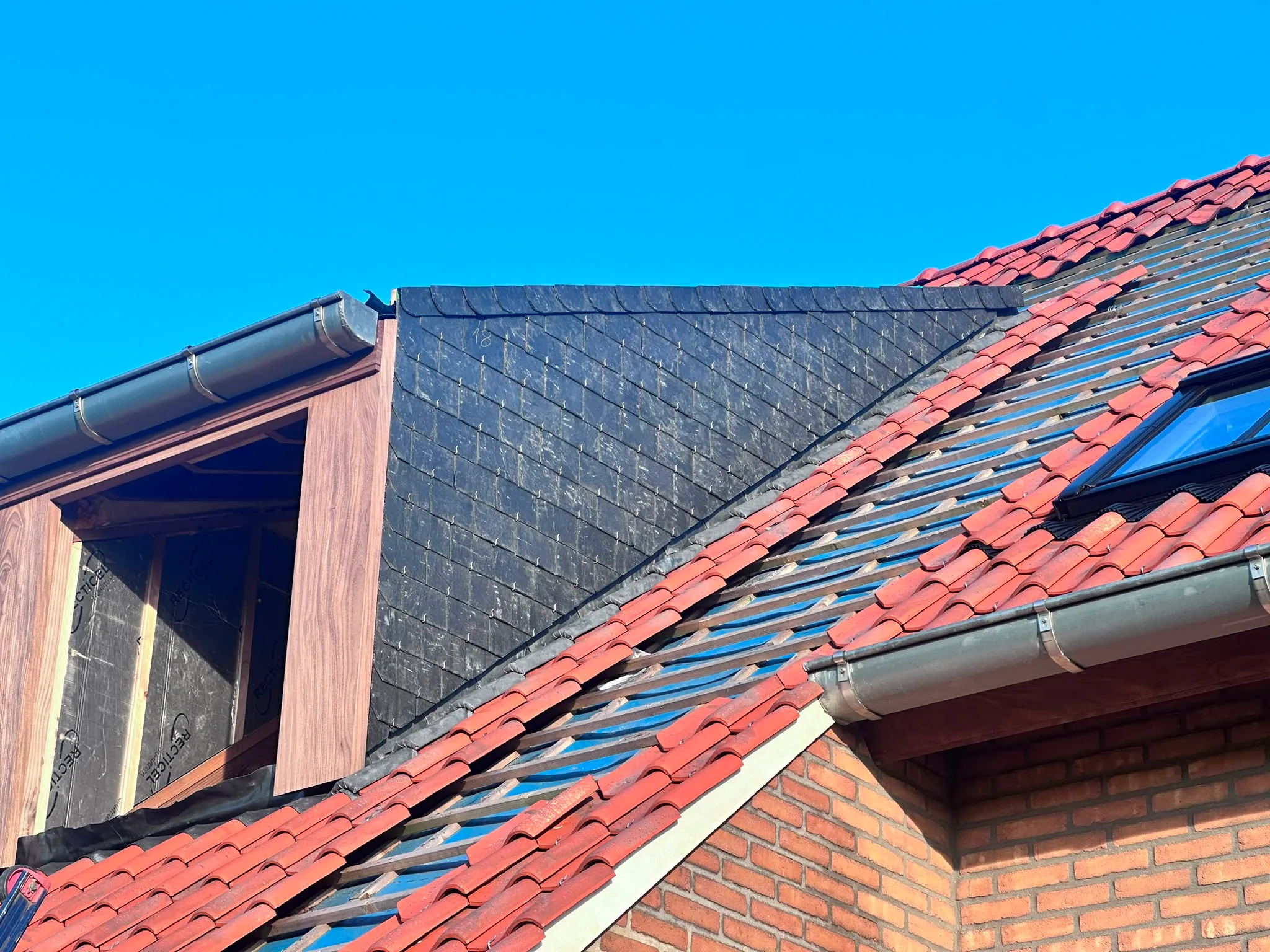 Dakpannen en metalen goten op woonhuis