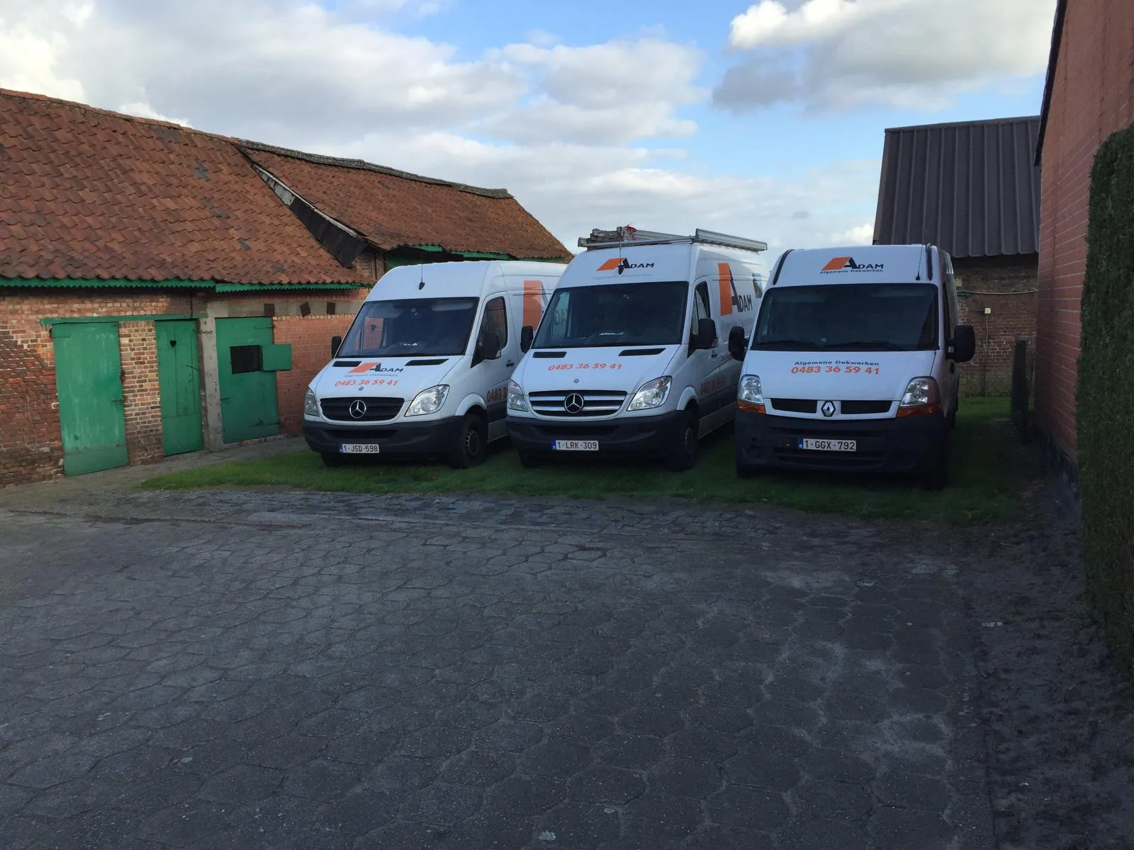 Drie witte bedrijfswagens op bedrijfsterrein