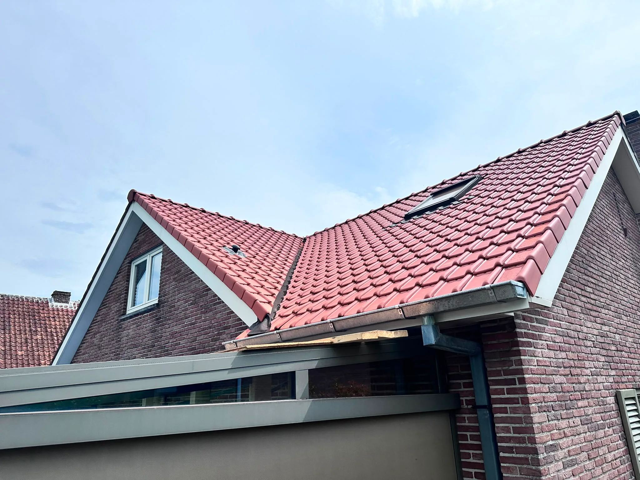 Nieuw rood dak op bakstenen woning