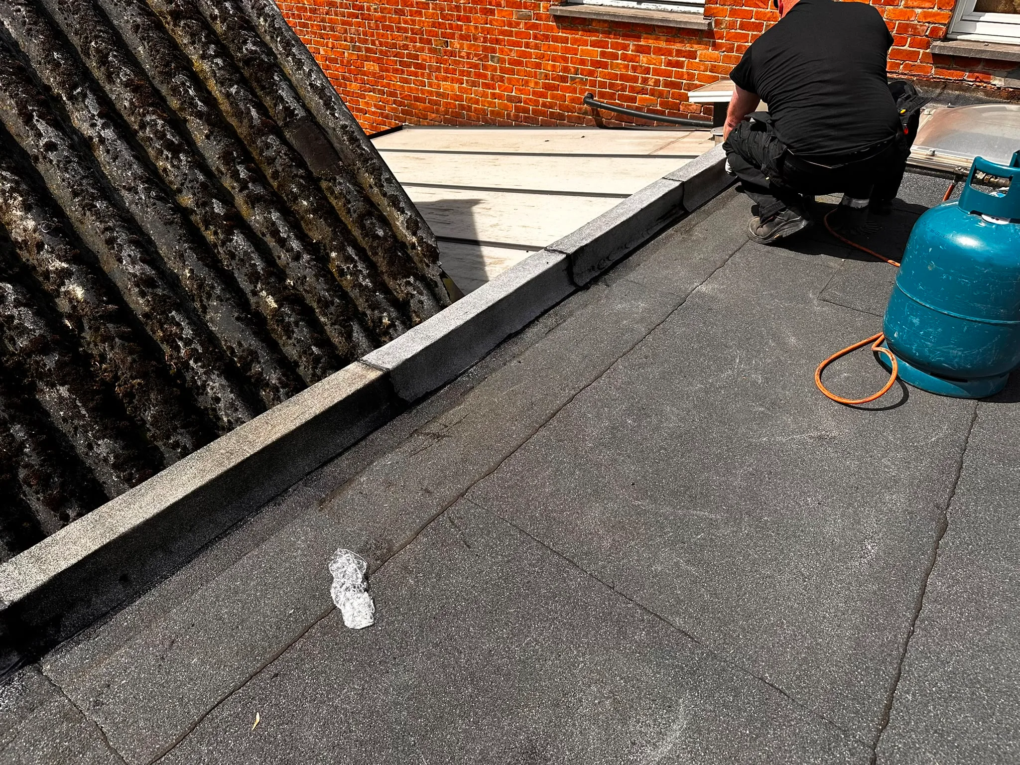 Werkzaamheden aan plat dak bakstenen gebouw