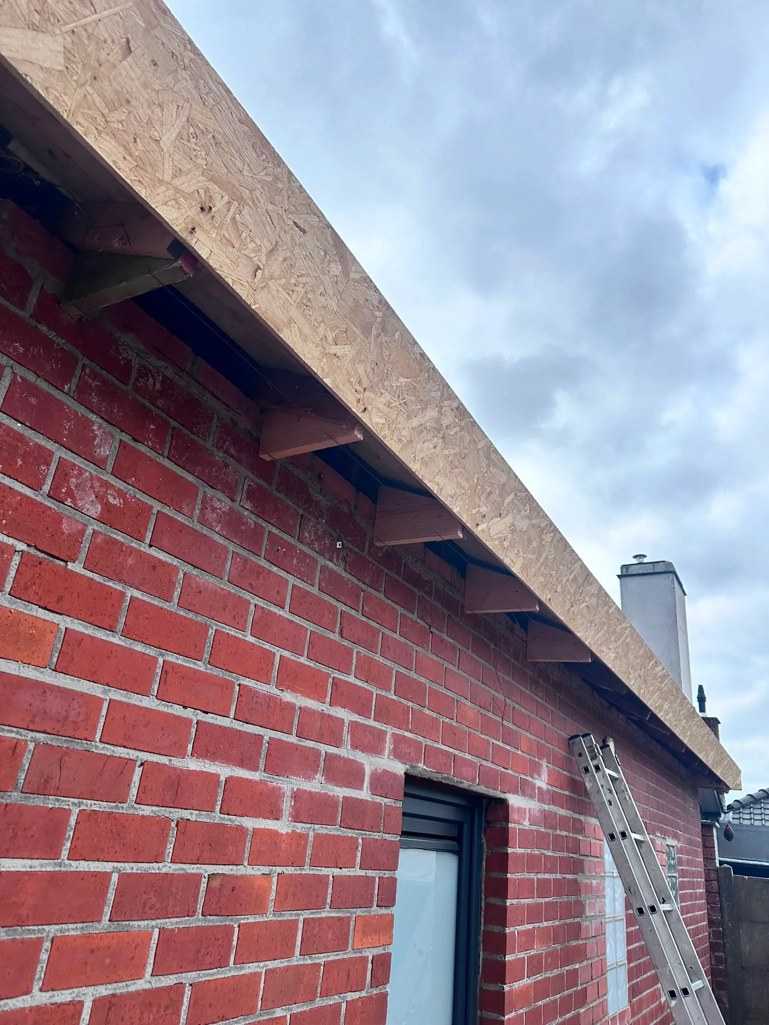 Dakconstructie op bakstenen gebouw in aanbouw
