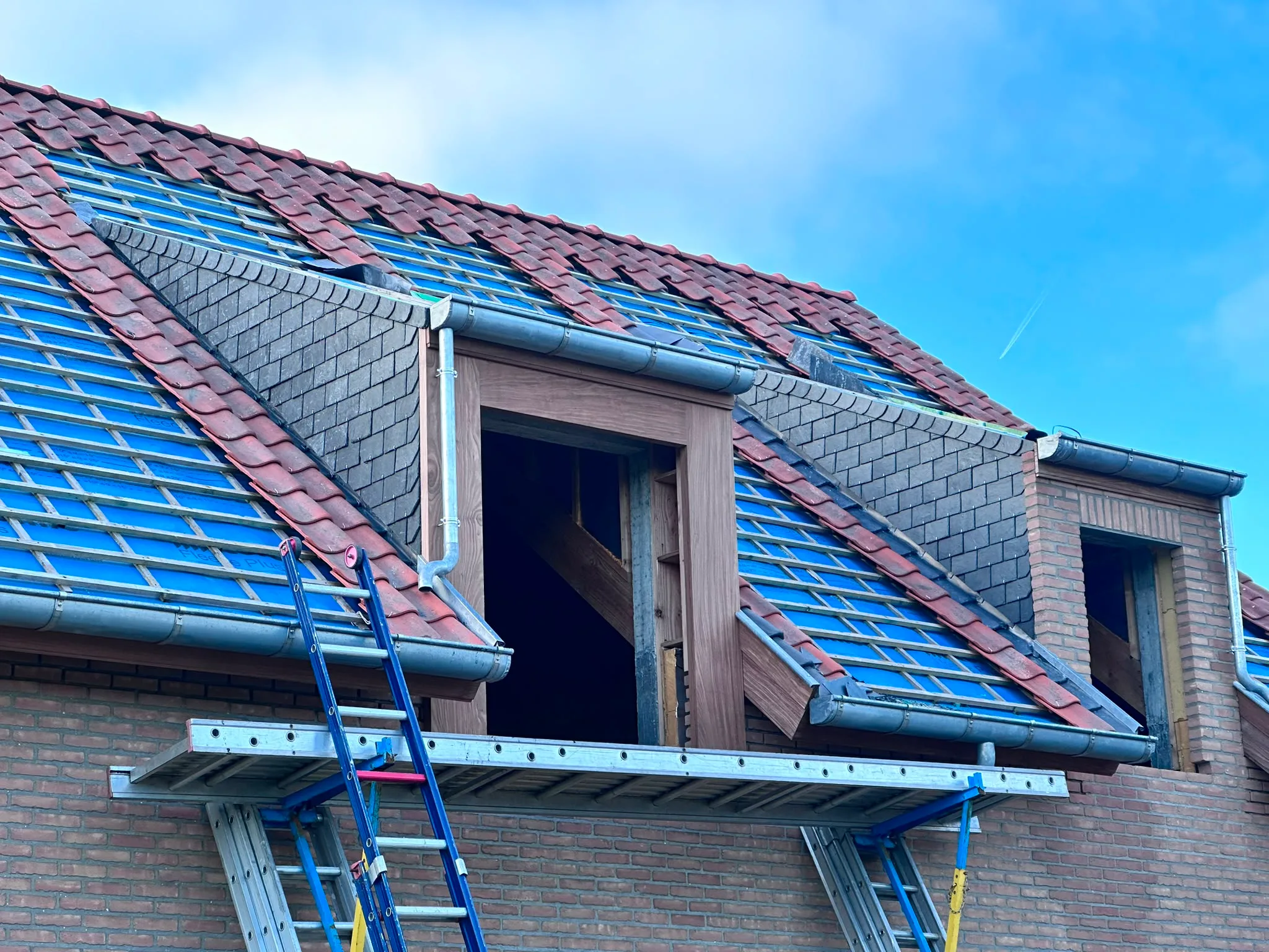 Dakrenovatie in uitvoering met nieuwe dakpannen en dakisolatie