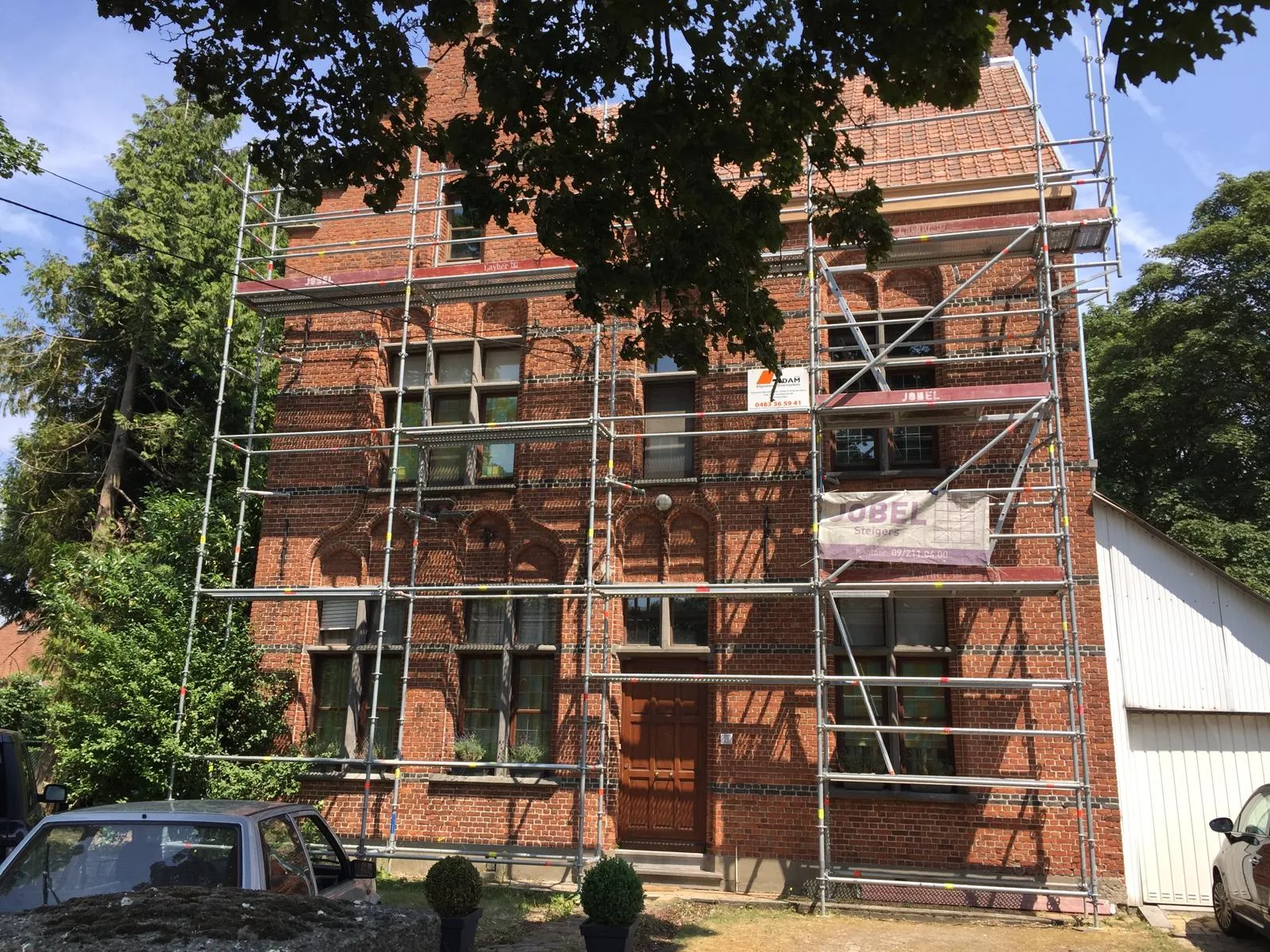 Bakstenen gebouw in aanbouw met steigers