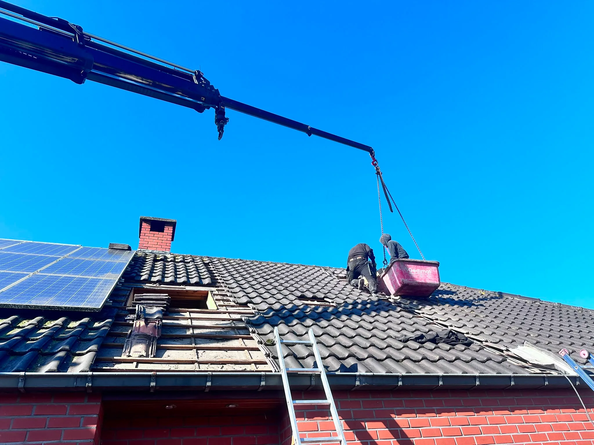 Dakwerkinstallatie op baksteenwoning met kraan