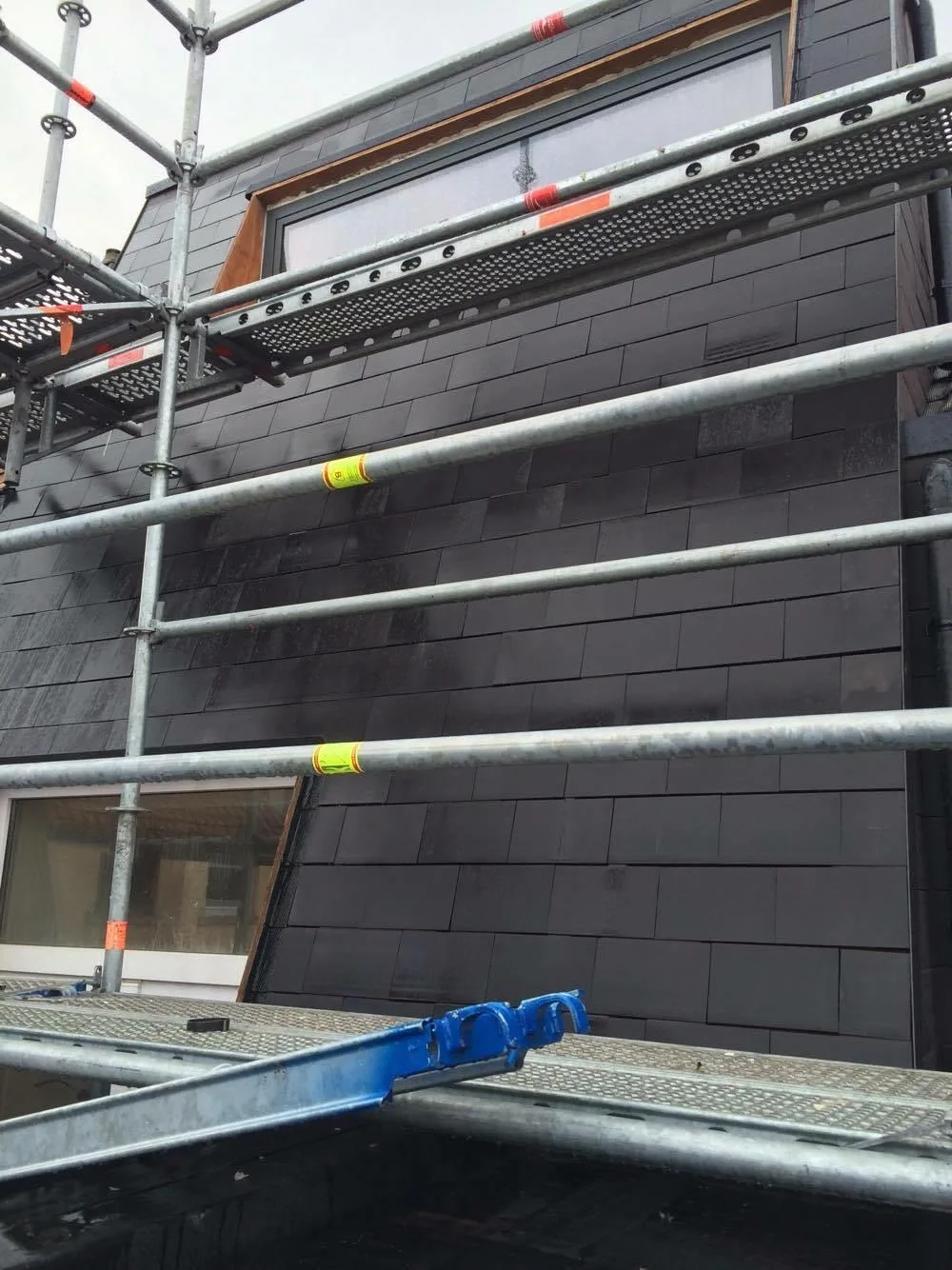 Dakwerk steigering op moderne donkere gevel
