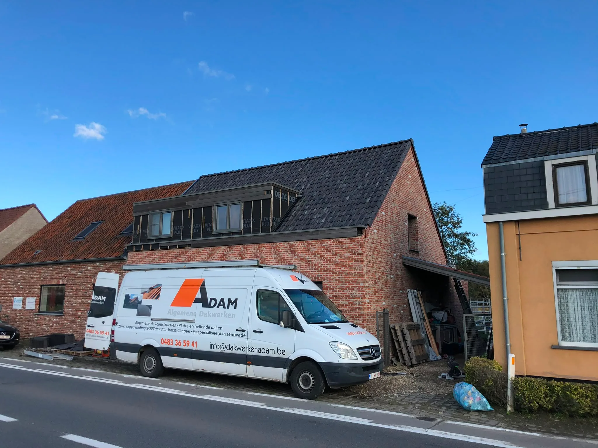 DAM dakwerkwagen bij bakstenen woning