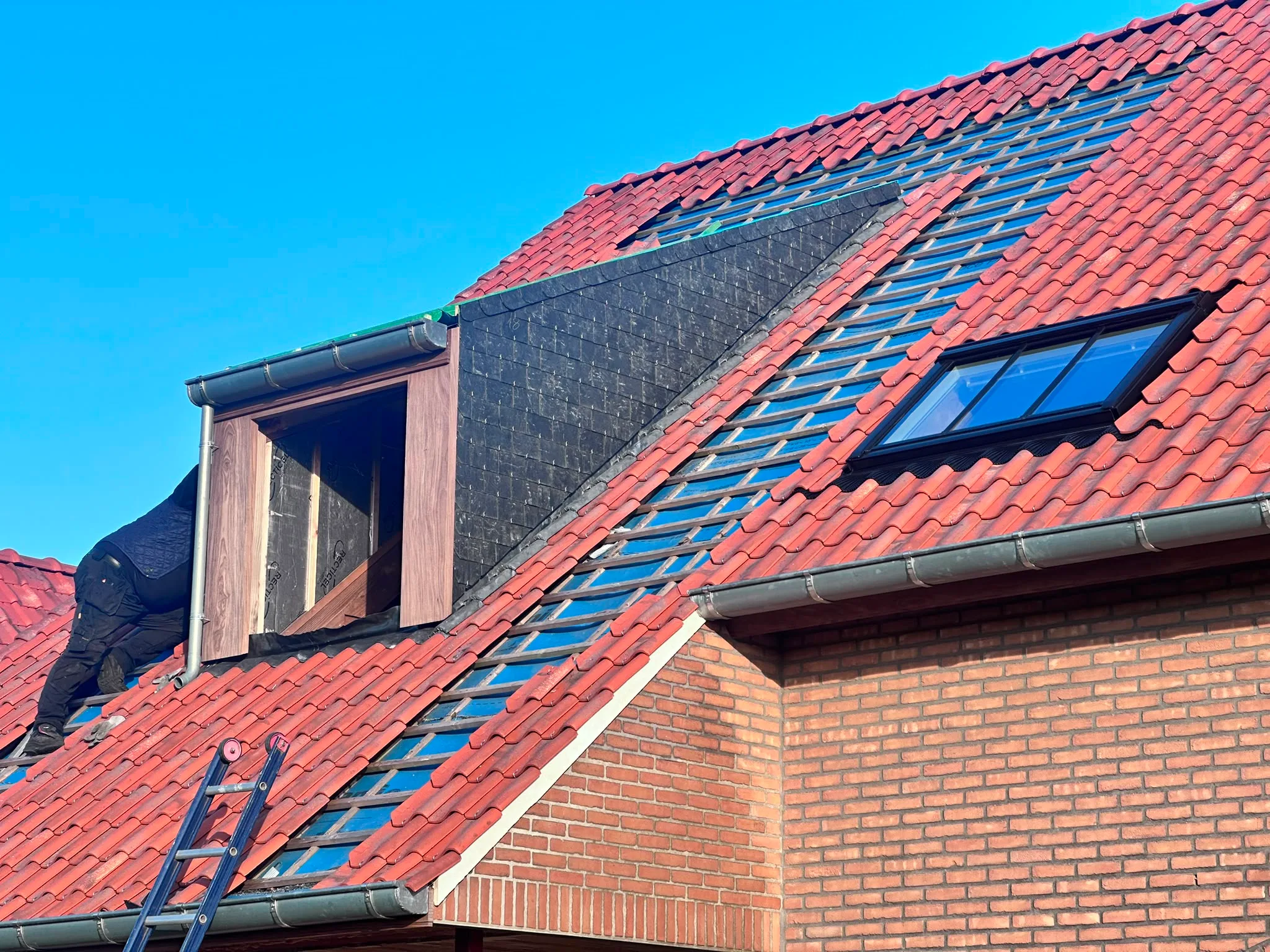 Nieuwe rode dakpannen met dakramen