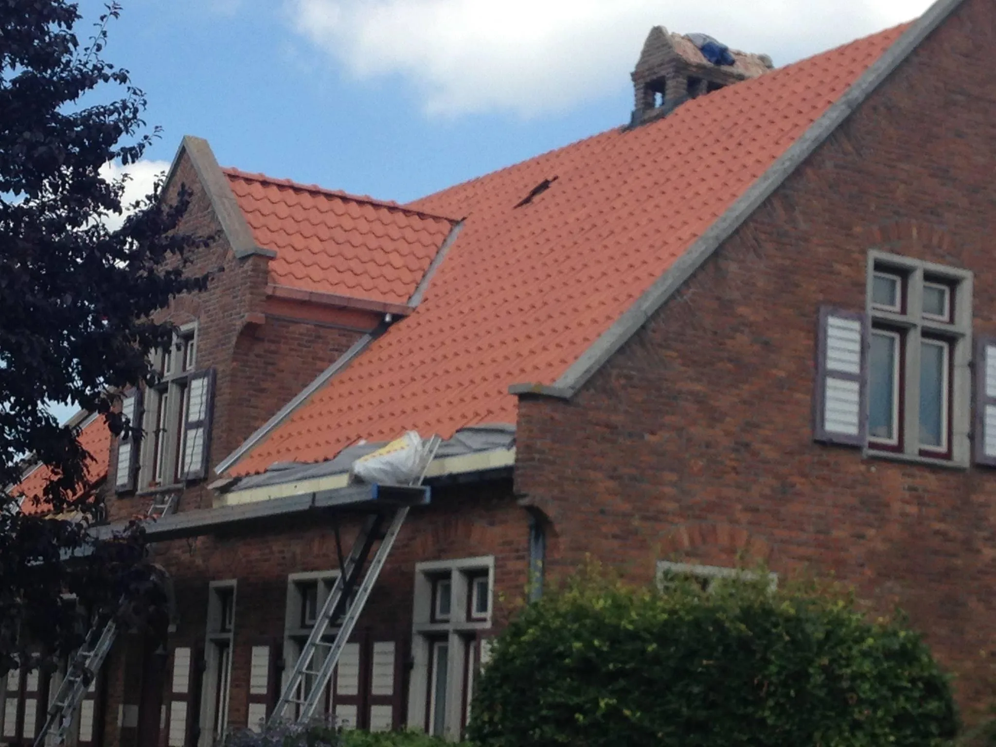 Rood pannendak aan bakstenen huis