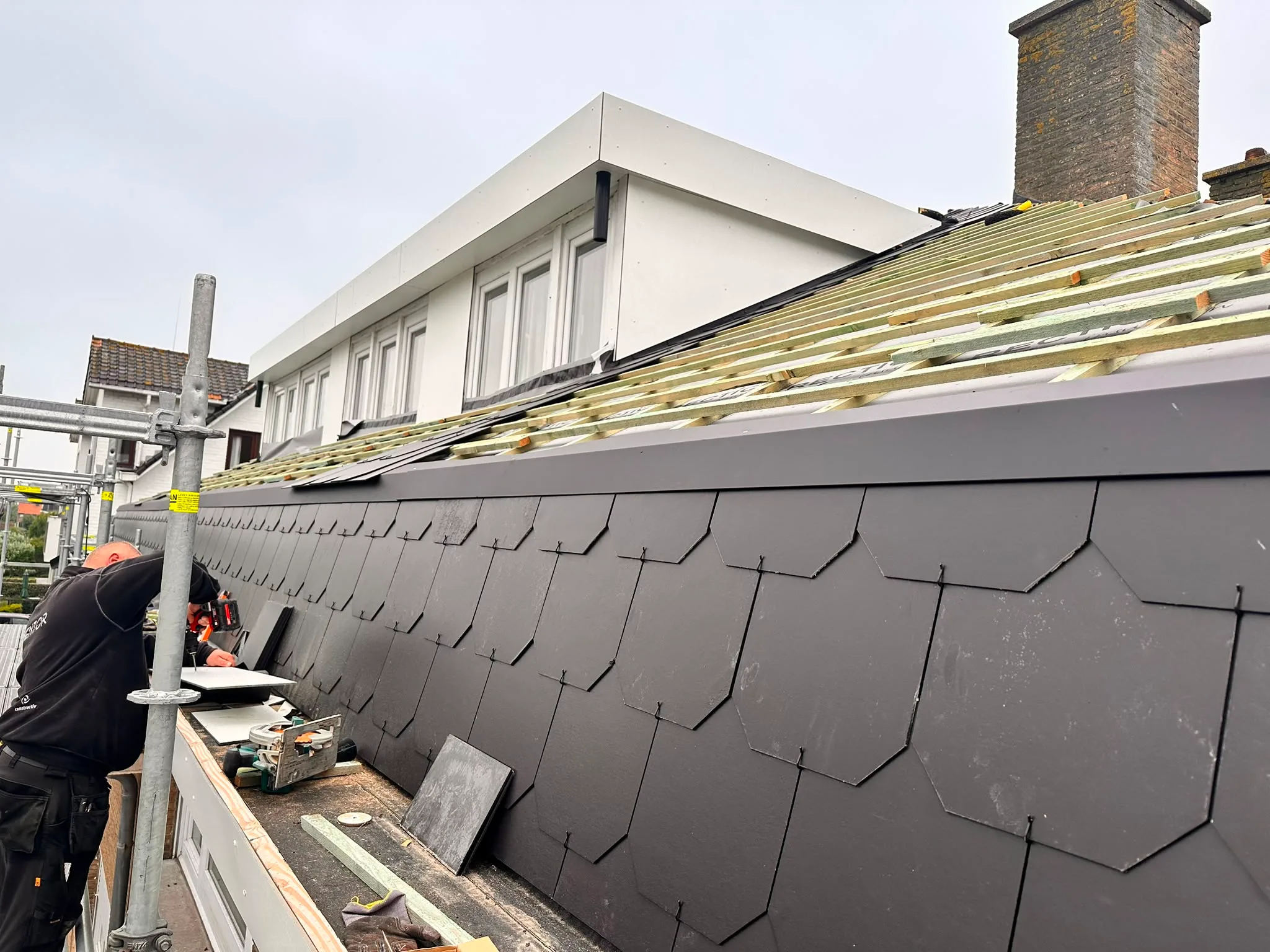 Montage zwarte dakpannen op woning
