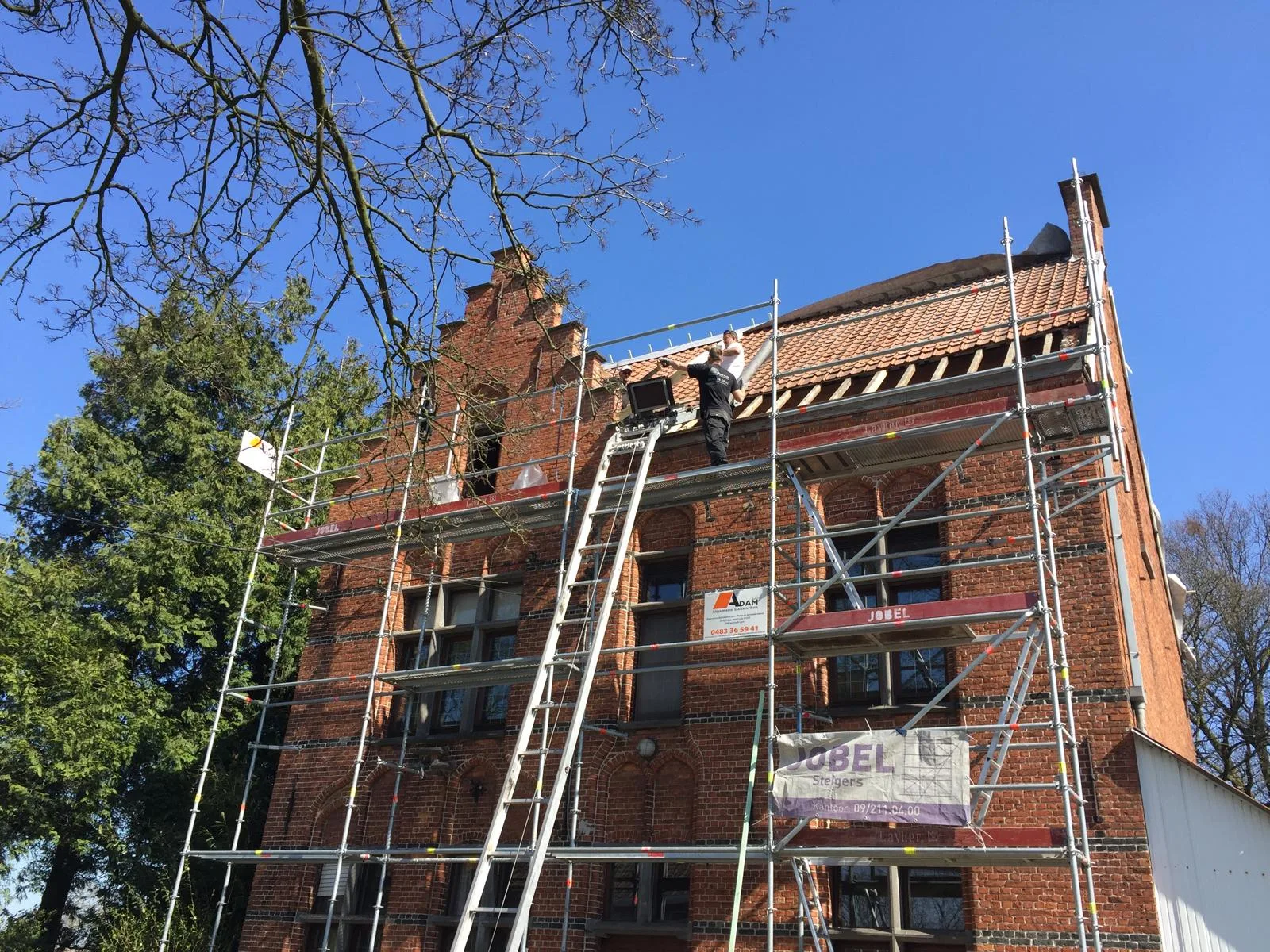 Bakstenen gebouw in restauratie met steigers