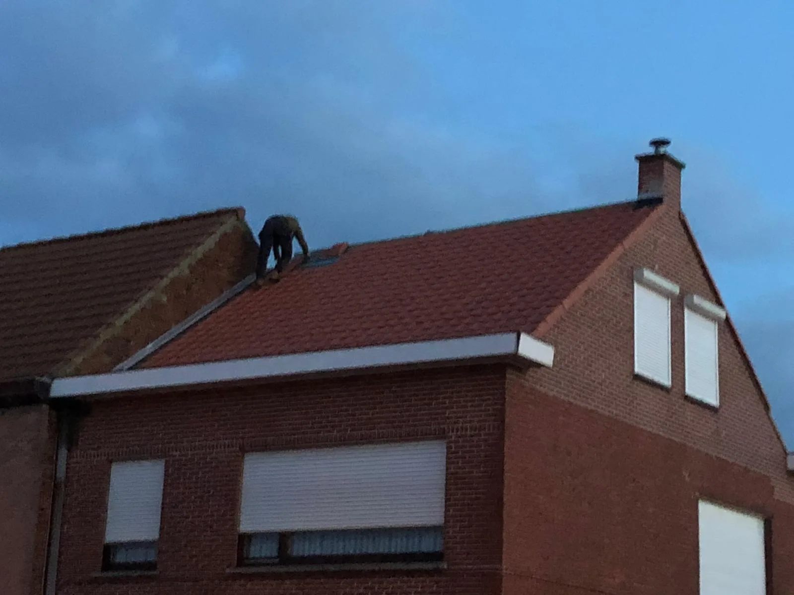 Dakwerker voert reparaties uit op huisdak