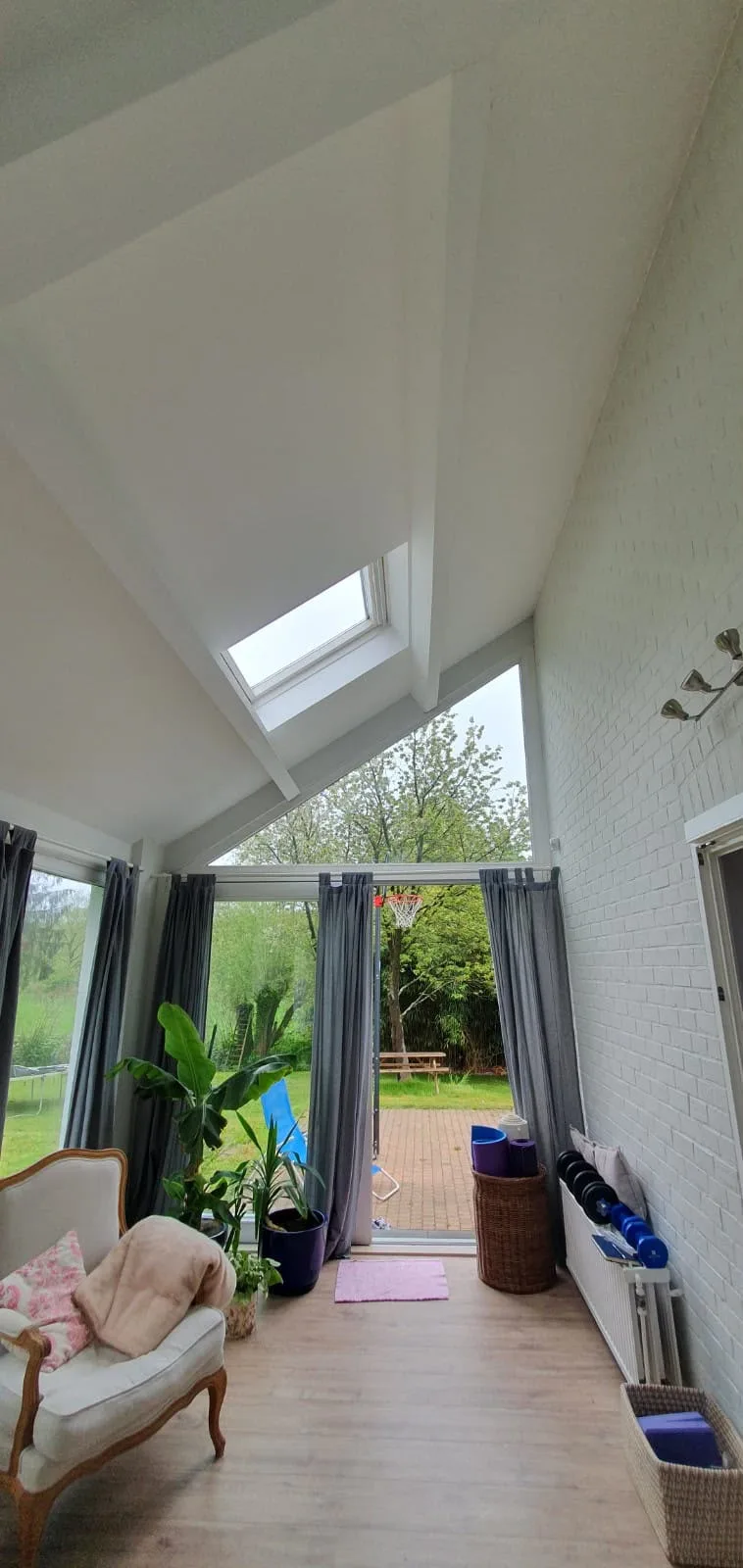 Moderne veranda met dakramen en tuinzicht
