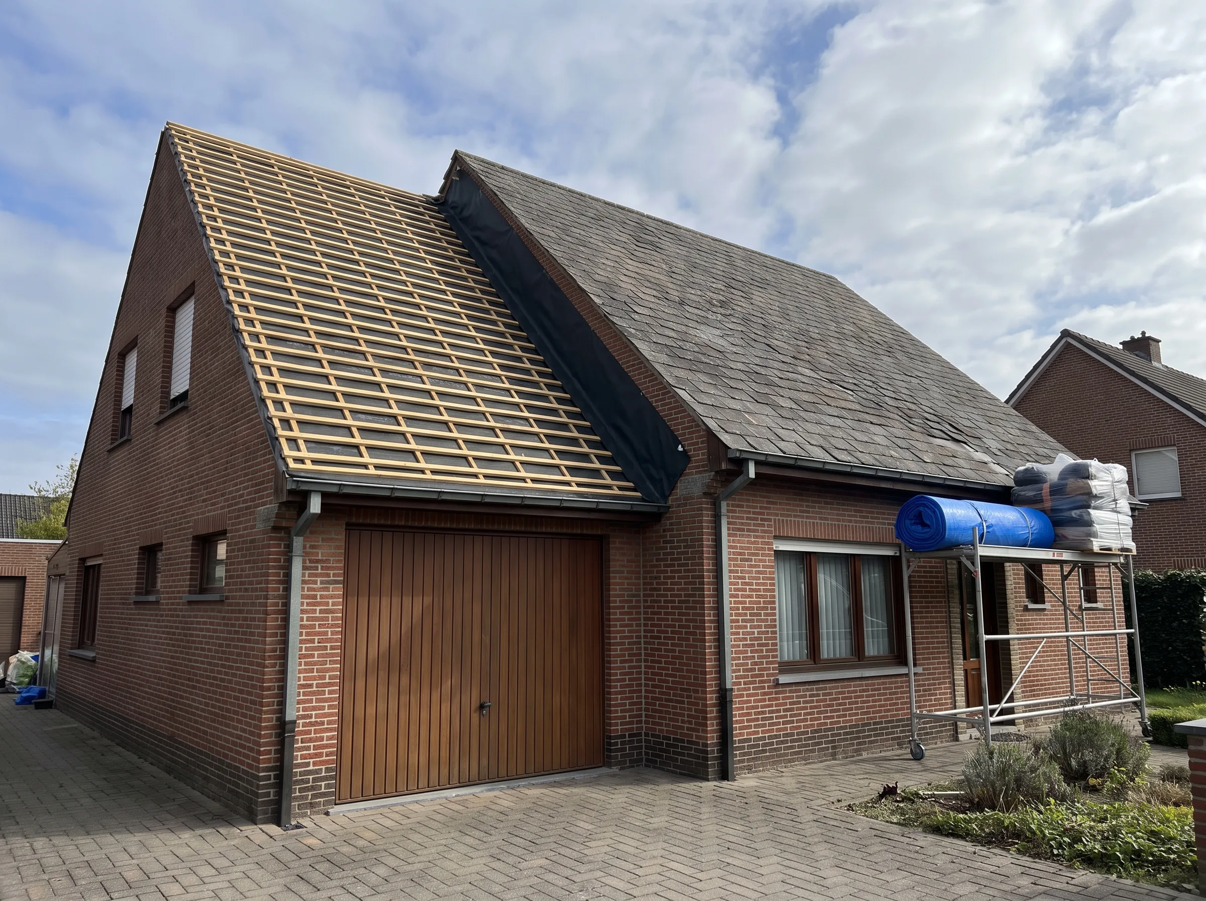 Dakrenovatie van een woning met nieuwe dakbedekking en een steiger voor werkzaamheden