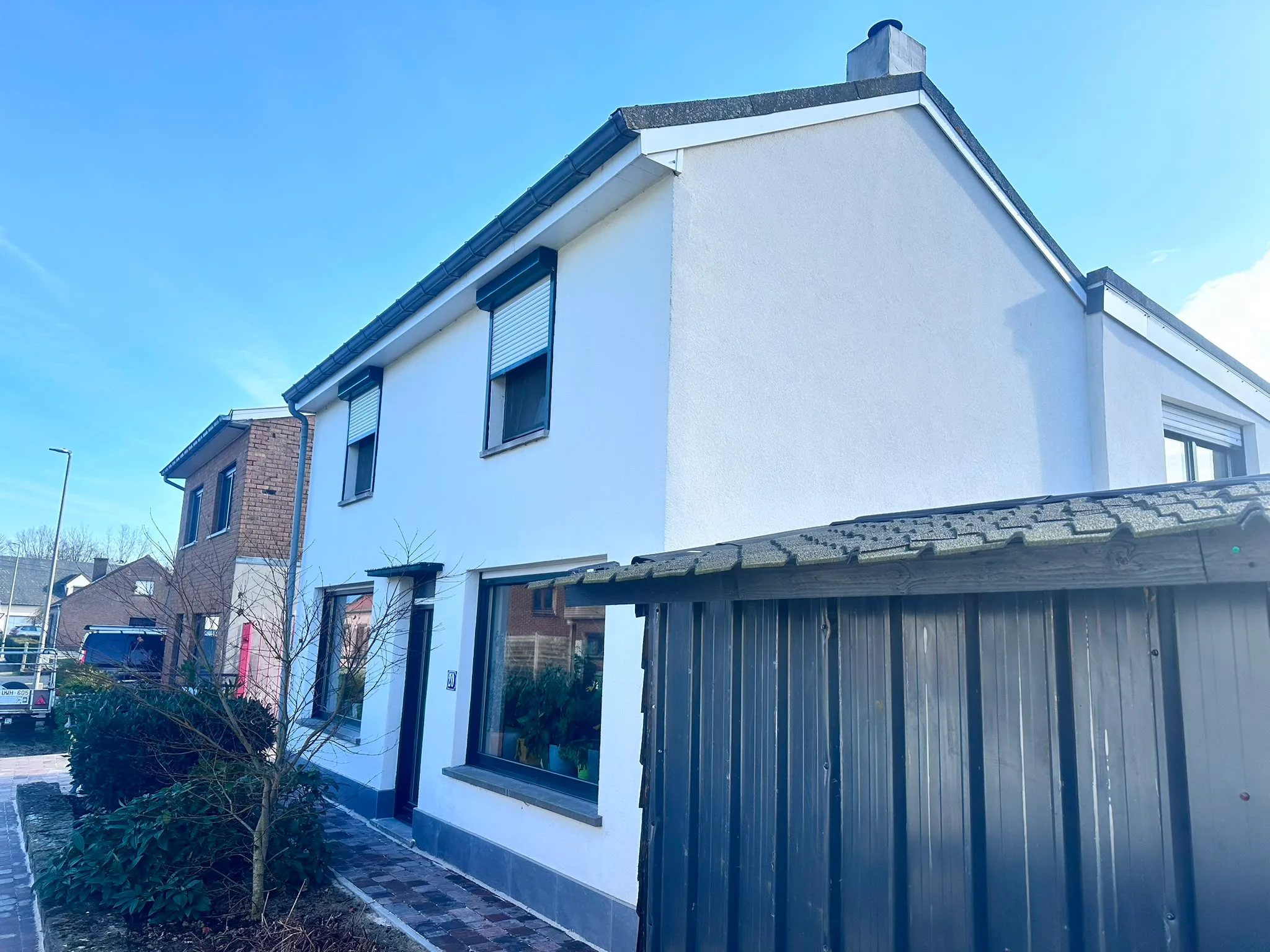 Gevelrenovatie van een huis met frisse witte muren en nieuwe ramen