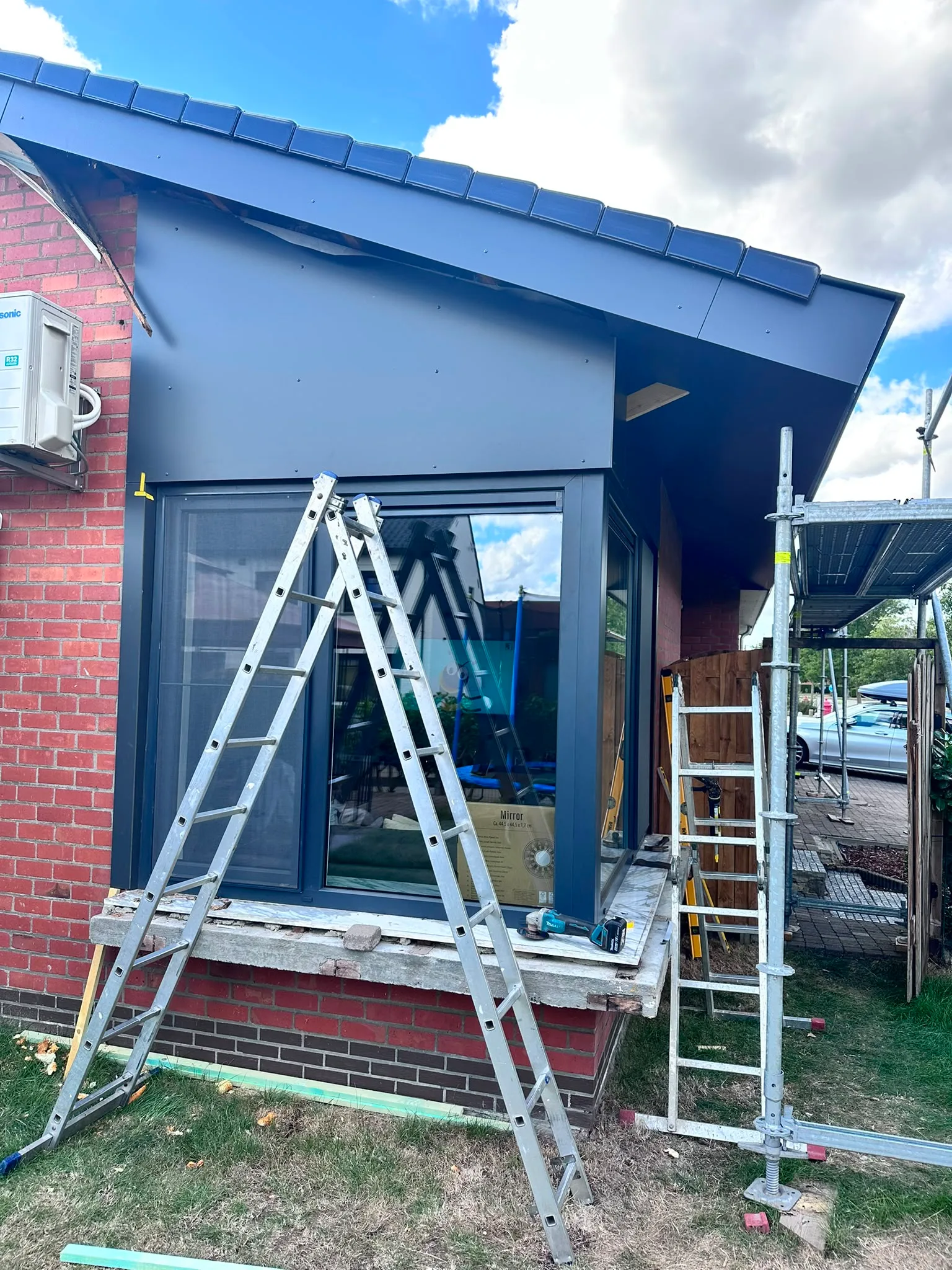 Dakrenovatie met ladders en dakbedekking in aanbouw